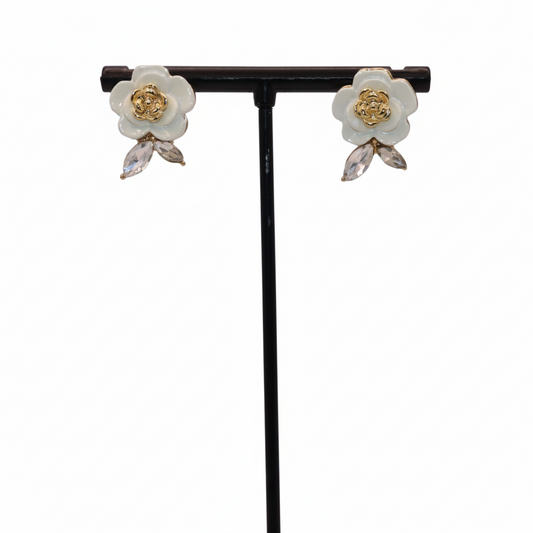 Floral earrings on a black stand against a white background