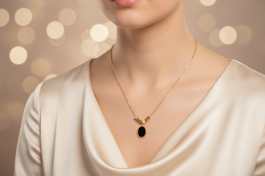 Gold necklace with a black oval pendant