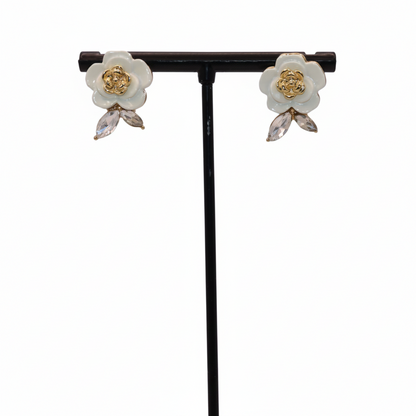 Floral earrings on a black stand against a white background