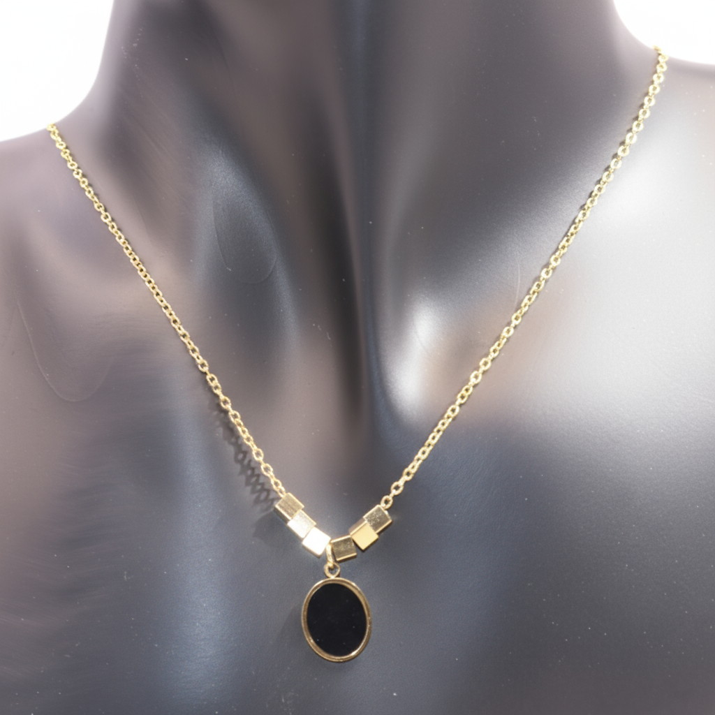 Gold necklace with a black oval pendant 